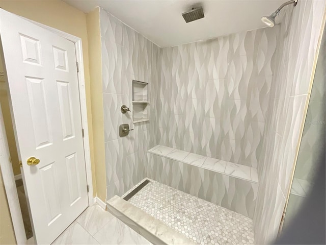 bathroom featuring tiled shower and tile walls