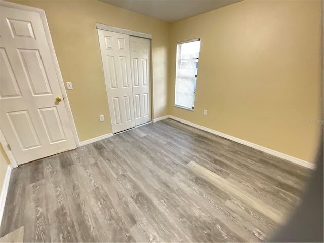 unfurnished bedroom with a closet and light wood-type flooring