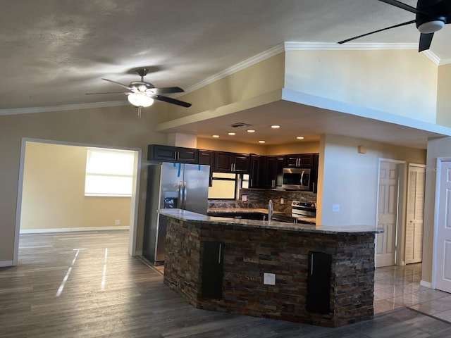 kitchen with backsplash, ornamental molding, stainless steel appliances, and light hardwood / wood-style flooring