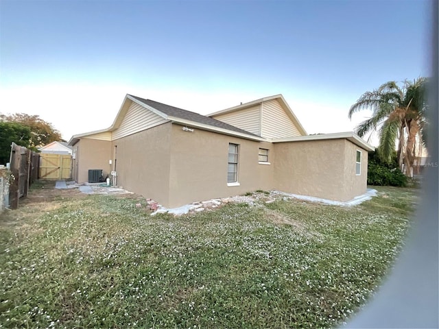 rear view of house featuring a yard and central AC