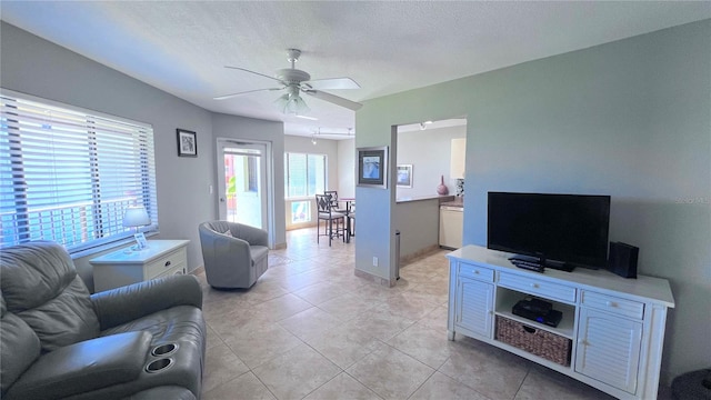 tiled living room featuring ceiling fan and a textured ceiling