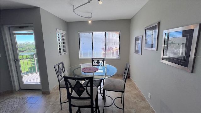 1515 Pinellas Bayway S Unit 35, Tierra Verde, FL 33715 - dining space with light tile patterned flooring, baseboards, and track lighting