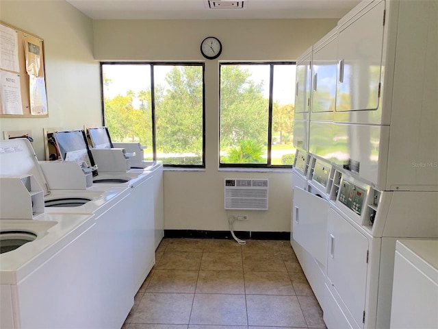 washroom featuring washing machine and clothes dryer, stacked washer / dryer, light tile patterned floors, and a wall mounted AC