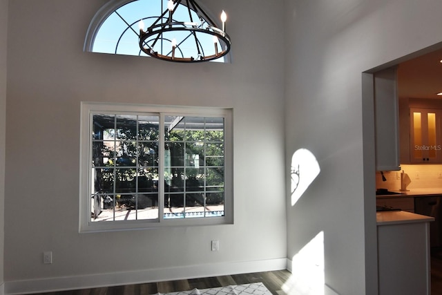 interior space featuring a notable chandelier, a towering ceiling, and hardwood / wood-style floors