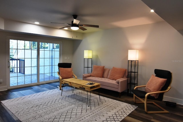 living room with ceiling fan and dark wood-type flooring