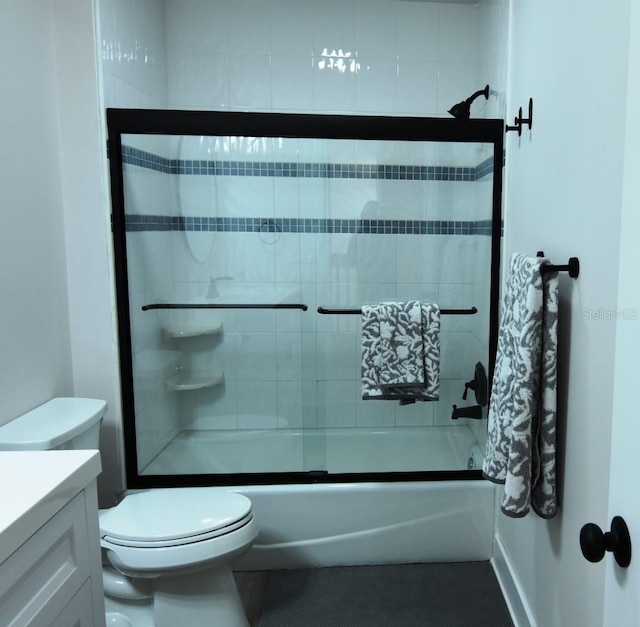 full bathroom featuring shower / bath combination with glass door, vanity, and toilet