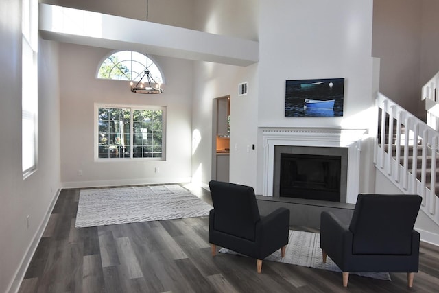 living room featuring a high ceiling, dark hardwood / wood-style floors, and a chandelier