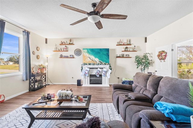 living room featuring hardwood / wood-style floors, a textured ceiling, and ceiling fan