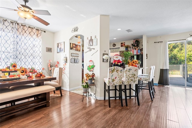 dining area featuring hardwood / wood-style flooring, ceiling fan, and a textured ceiling