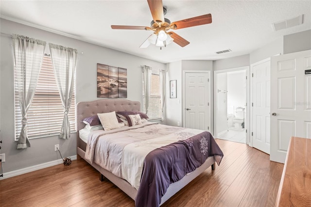 bedroom with connected bathroom, ceiling fan, and hardwood / wood-style flooring