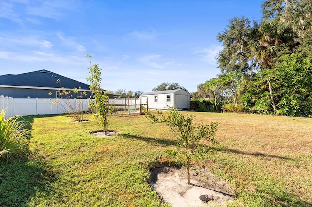 view of yard featuring an outbuilding, a storage unit, and a fenced backyard