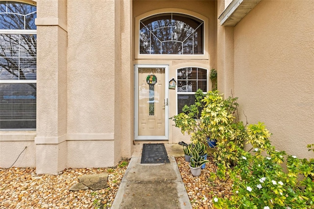 doorway to property featuring stucco siding