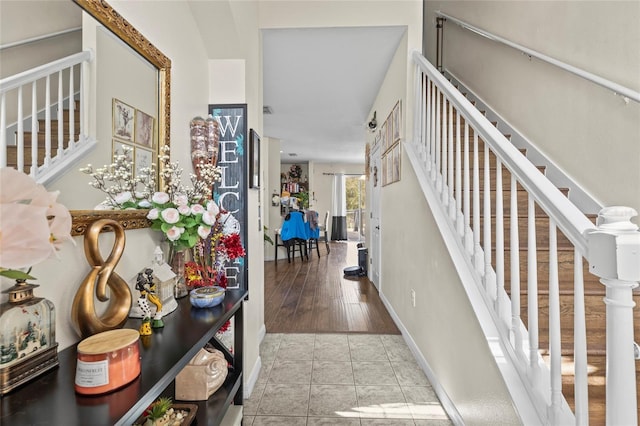 entryway with stairway, baseboards, and light tile patterned floors