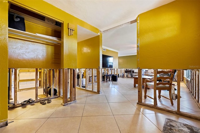 hallway featuring tile patterned floors and ornamental molding