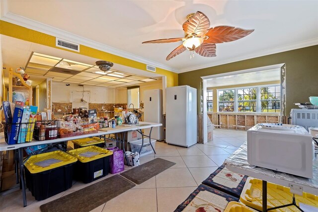 kitchen with ceiling fan, white refrigerator, light tile patterned floors, and crown molding