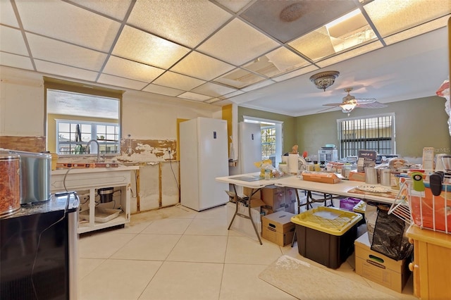 kitchen featuring light tile patterned floors, a paneled ceiling, ceiling fan, and sink