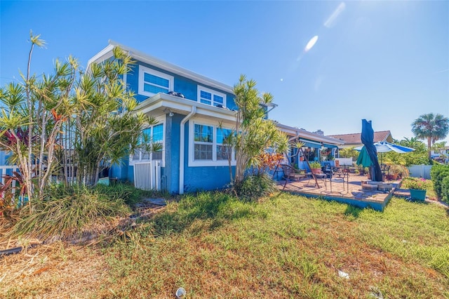 back of property featuring a lawn and a patio area