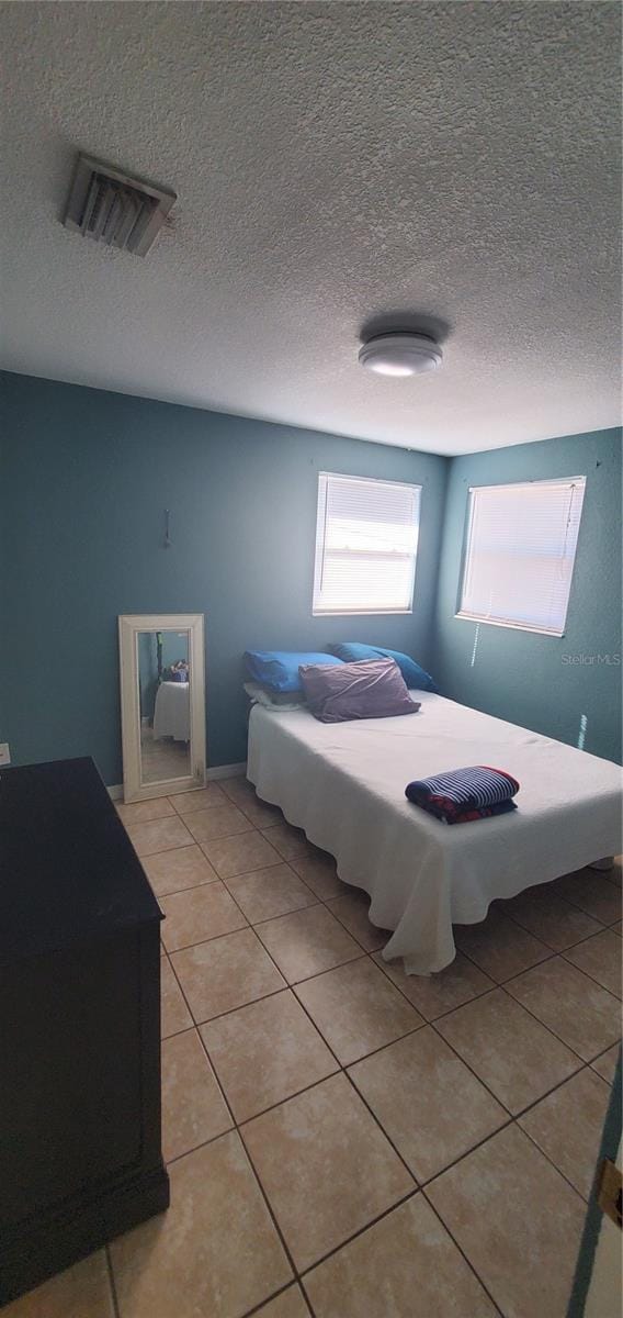 bedroom featuring a textured ceiling and light tile patterned flooring