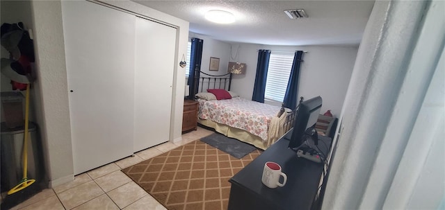 bedroom featuring light tile patterned floors and a textured ceiling