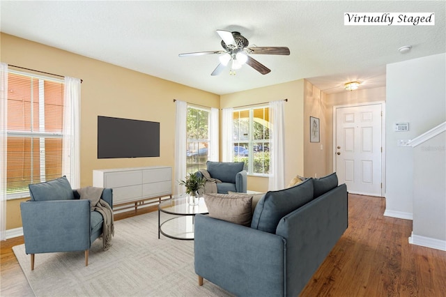 living room featuring ceiling fan, a textured ceiling, and light hardwood / wood-style flooring