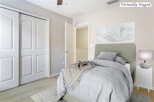 bedroom with ceiling fan, light colored carpet, radiator, and a closet