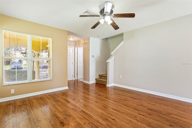 unfurnished living room featuring ceiling fan and dark hardwood / wood-style flooring