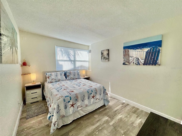 bedroom featuring a textured ceiling and hardwood / wood-style flooring