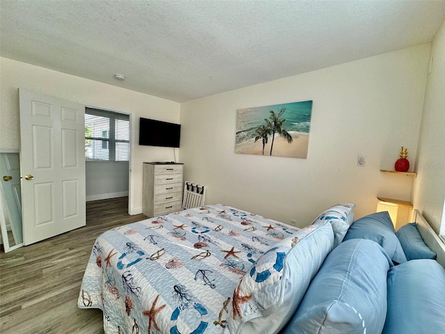 bedroom featuring a textured ceiling and hardwood / wood-style flooring