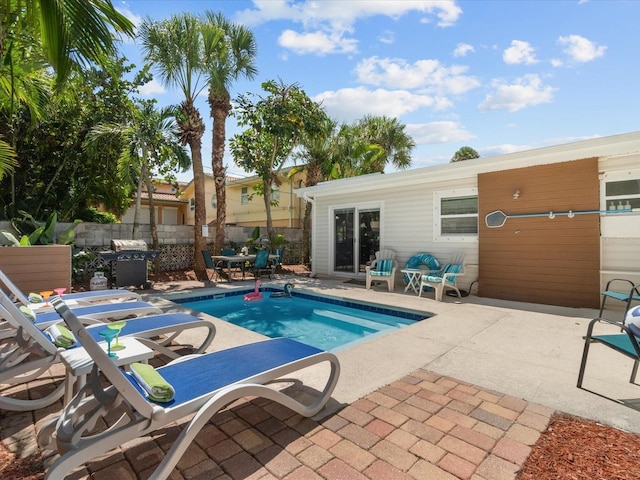 view of pool featuring a patio area and a grill