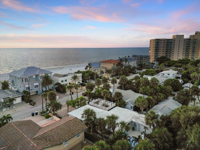 aerial view at dusk featuring a water view