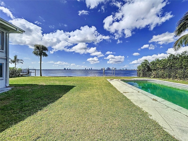 view of yard with a fenced in pool and a water view