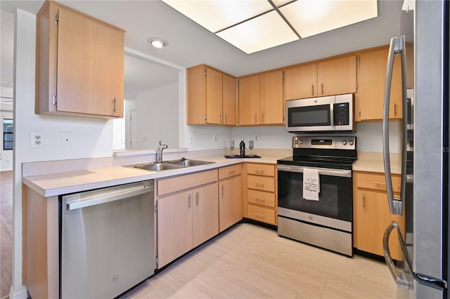 kitchen with light brown cabinets, sink, stainless steel appliances, and light hardwood / wood-style flooring