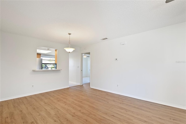 2122 Hereford Dr Unit 511, Sun City Center, FL 33573 - spare room with ceiling fan, light wood-style flooring, baseboards, and a textured ceiling