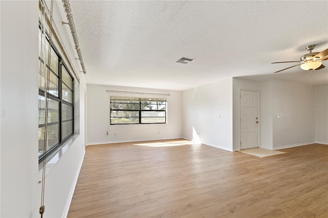 spare room with ceiling fan, light hardwood / wood-style floors, and a textured ceiling