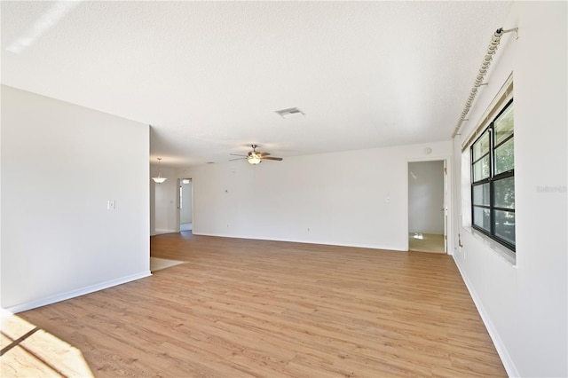 unfurnished room featuring ceiling fan, a textured ceiling, and light wood-type flooring