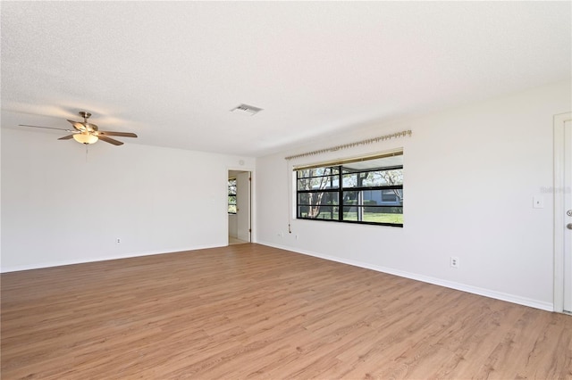 unfurnished room featuring a textured ceiling, light wood-type flooring, and ceiling fan