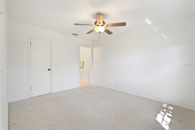 unfurnished bedroom featuring ceiling fan, light carpet, and a closet