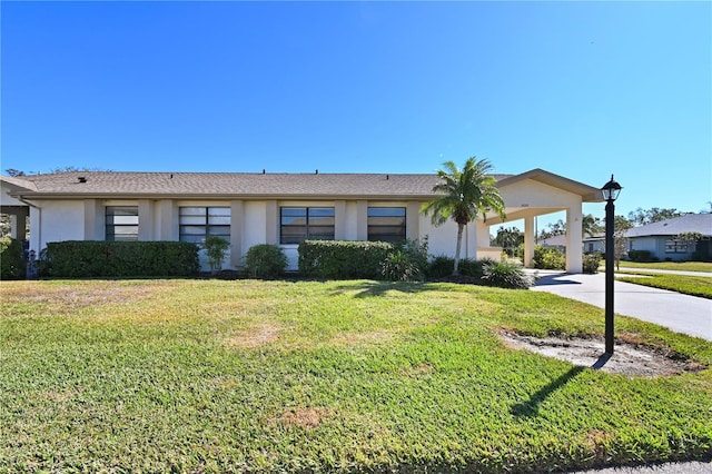 2122 Hereford Dr Unit 511, Sun City Center, FL 33573 - ranch-style house featuring stucco siding, a front lawn, concrete driveway, and a carport