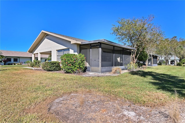 2122 Hereford Dr Unit 511, Sun City Center, FL 33573 - back of property with a sunroom, a lawn, an attached garage, and stucco siding