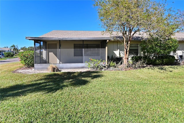 rear view of house with a sunroom and a yard