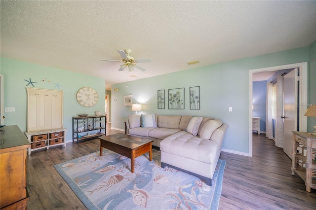 living room with ceiling fan, dark hardwood / wood-style flooring, and a textured ceiling