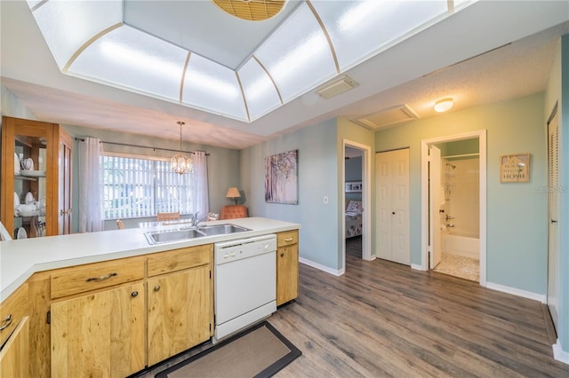 kitchen with pendant lighting, dishwasher, sink, hardwood / wood-style flooring, and a chandelier