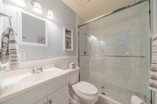 bathroom with walk in shower, vanity, and toilet