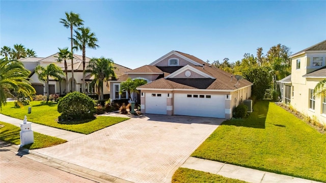 view of front of home with a garage, a front lawn, and cooling unit