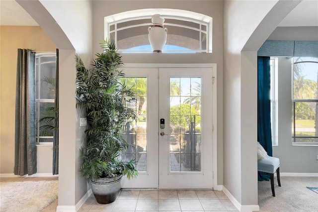 doorway with light tile patterned floors and french doors