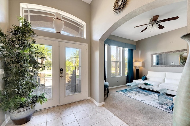 entryway featuring french doors, ceiling fan, and light tile patterned flooring