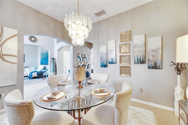 dining area with light carpet and a chandelier