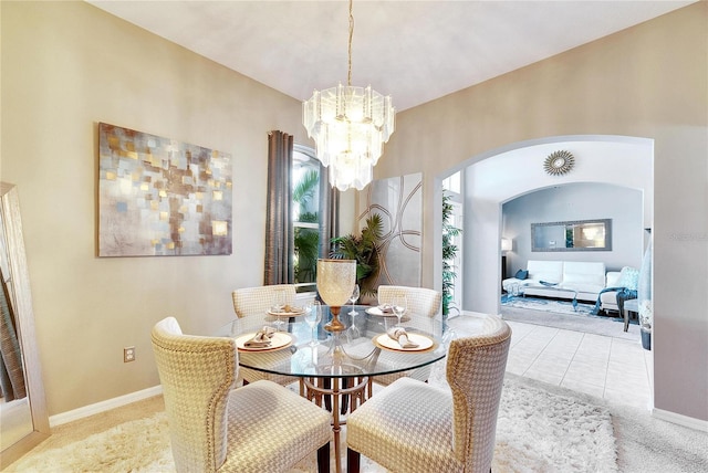 carpeted dining area with a chandelier