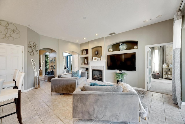 tiled living room with built in shelves and a textured ceiling