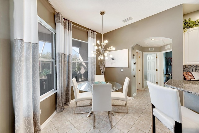 dining space featuring light tile patterned floors and a notable chandelier